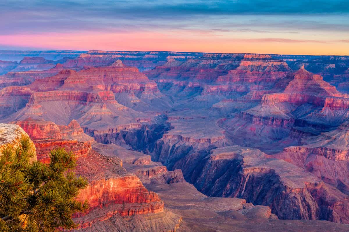 Grand Canyon canyon expanse in vivid magenta twilight beside Layered cliffs in Grand Canyon National Park, Arizona, United States.