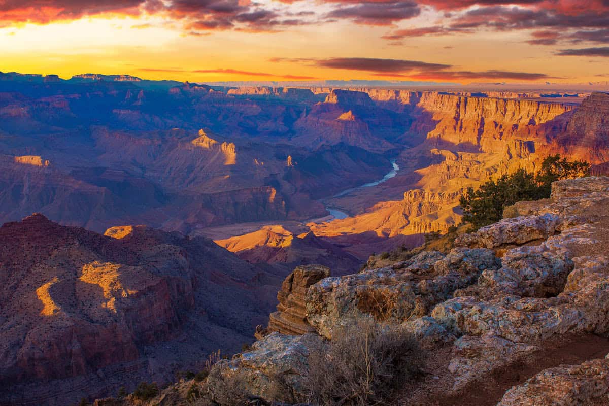 Grand Canyon cliffs glowing beneath a sunset sky above Distant plateau in Grand Canyon National Park, Arizona, United States.